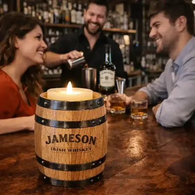 Branded oak barrel candle holder on bar top with bartender and guests, premium distillery promotional product driving brand visibility